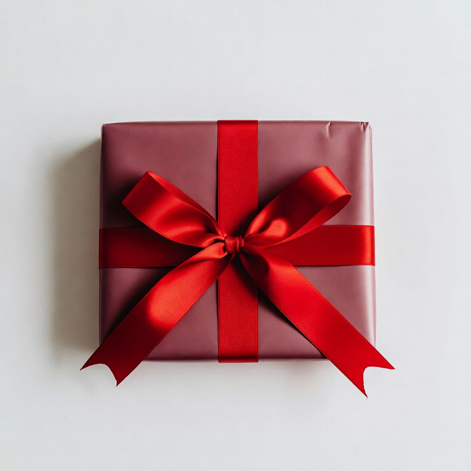 Red gift box with a large red bow on a light gray background
