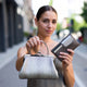 Woman holding a handbag and wallet on a city street